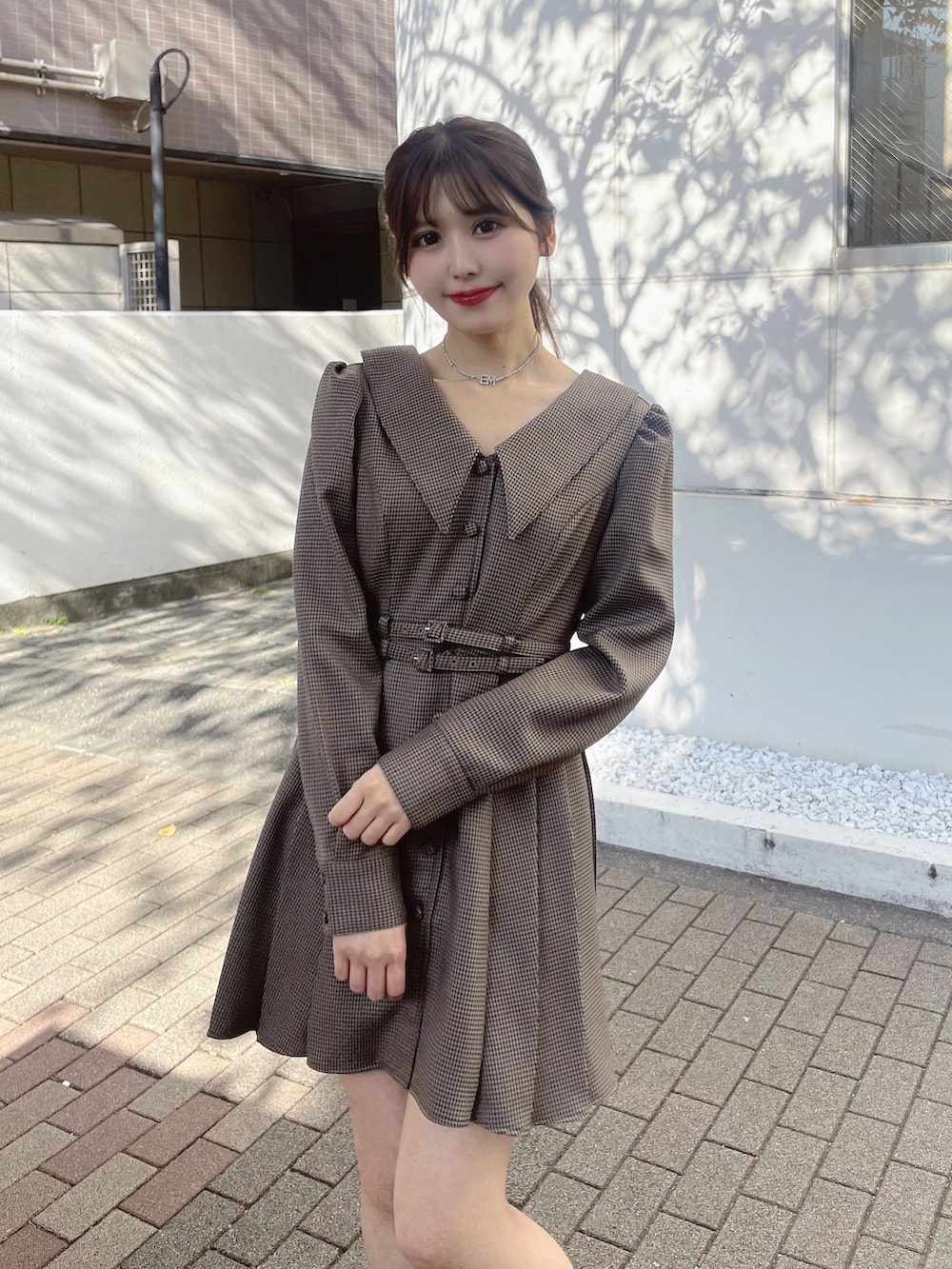 ブラウン系のワンピース、ベージュ系のその他アウター、ブラック系のローファーを着用したレディースの冬コーディネートの6枚目の写真