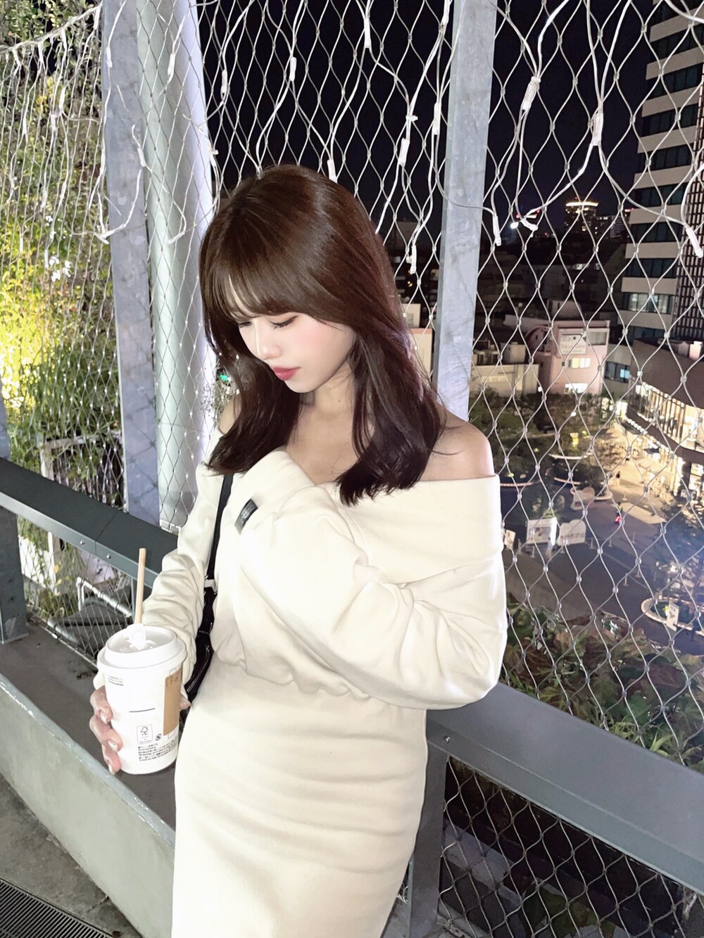 ブラック系のショルダーバッグ、ホワイト系のワンピースを着用したレディースの秋コーディネートの6枚目の写真