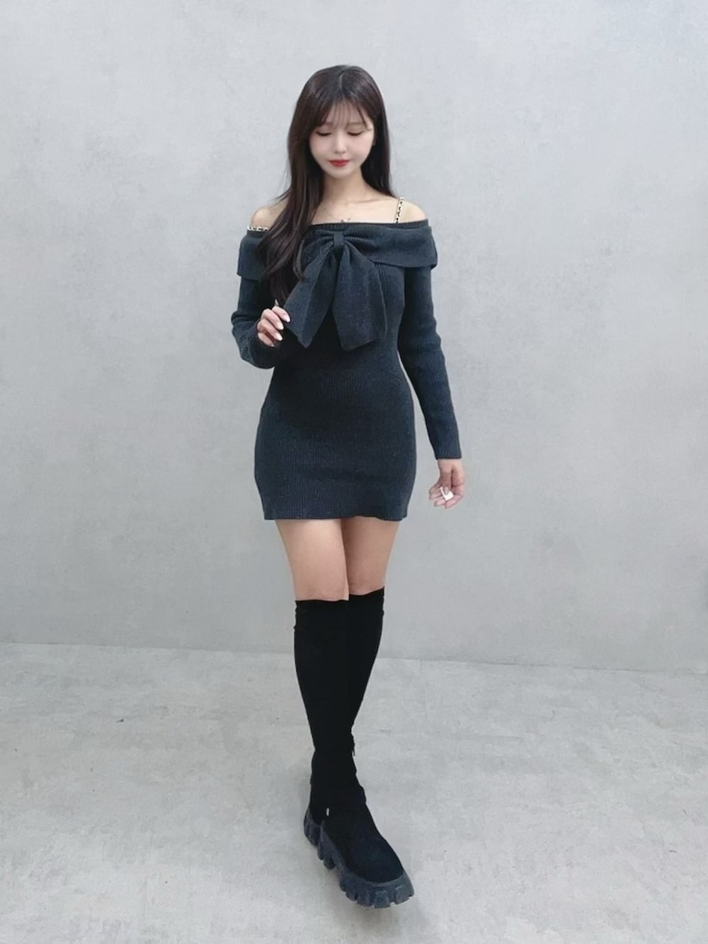 グレー系のワンピース、ブラック系のブーツを着用したレディースの冬コーディネートの2枚目の写真