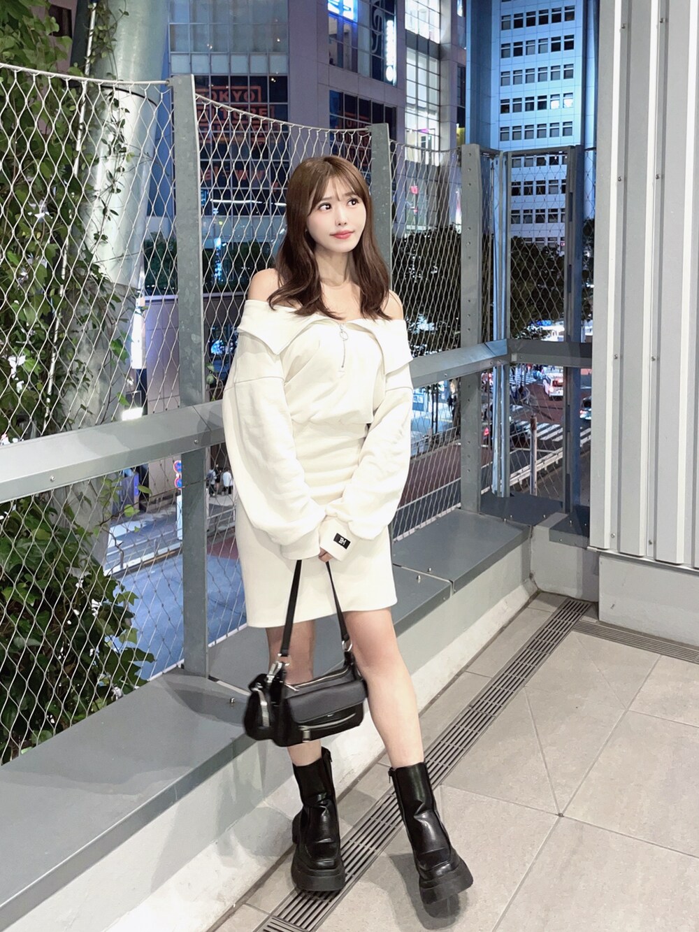 ブラック系のショルダーバッグ、ホワイト系のワンピースを着用したレディースの秋コーディネートの2枚目の写真