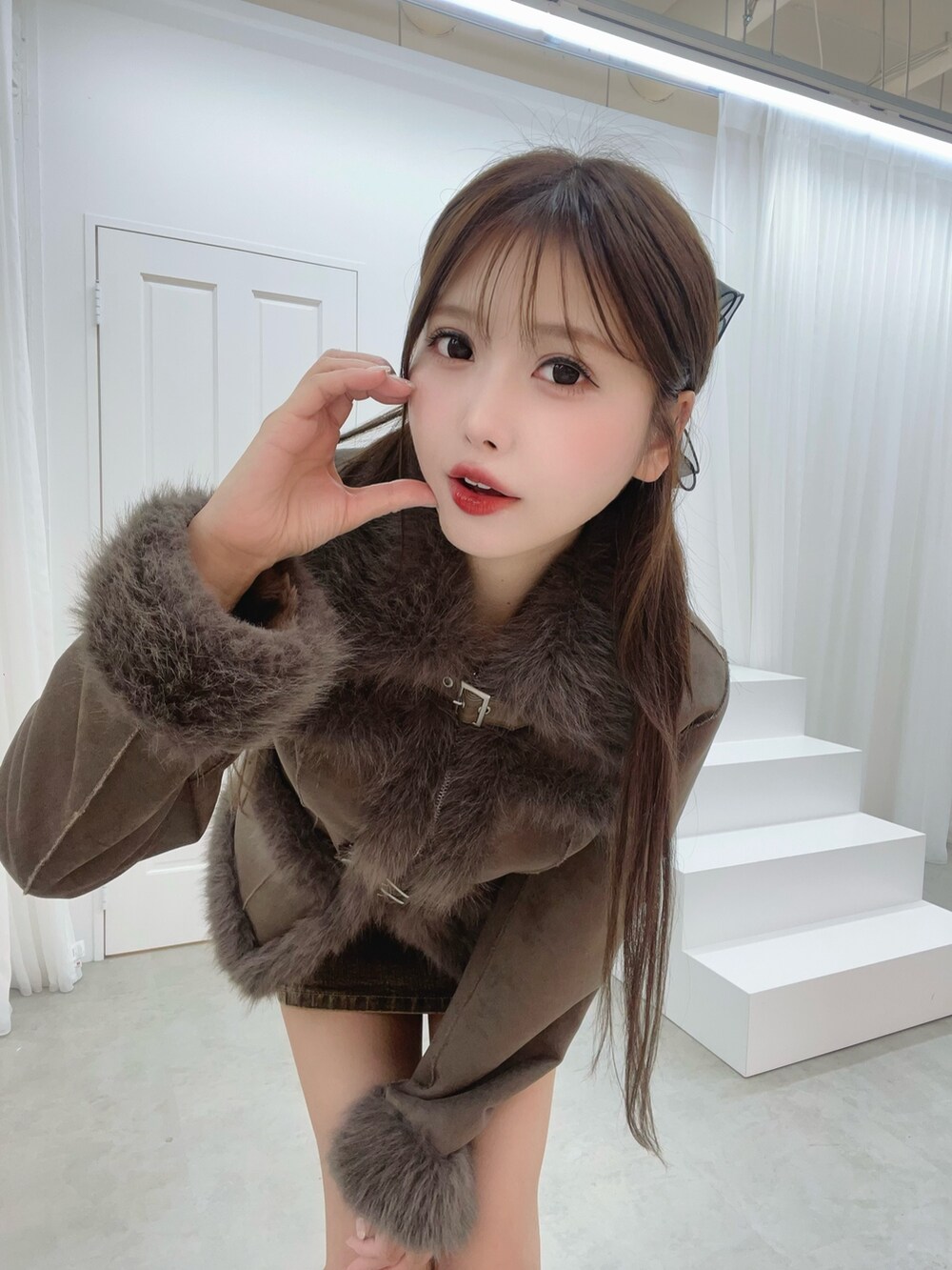 ホワイト系のブーツ、ブラウン系のブルゾン、ブラウン系のデニムスカートを着用したレディースの夏コーディネートの6枚目の写真