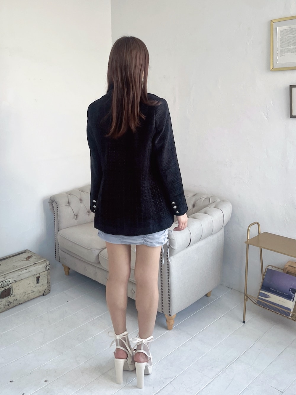 ブルー系のキャミソール、ブラック系のテーラードジャケット、ブルー系のスカートを着用したレディースの春コーディネートの6枚目の写真