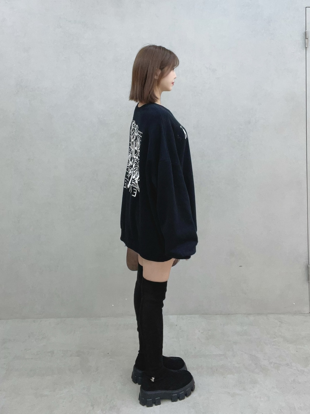 ブラック系のスウェット、ブラック系のブーツ、ブラウン系のショルダーバッグを着用したレディースの秋コーディネートの4枚目の写真