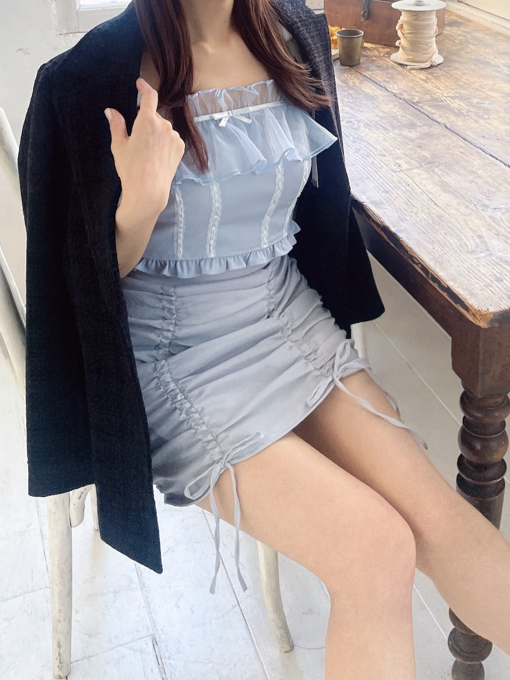 ブルー系のキャミソール、ブラック系のテーラードジャケット、ブルー系のスカートを着用したレディースの春コーディネートの7枚目の写真