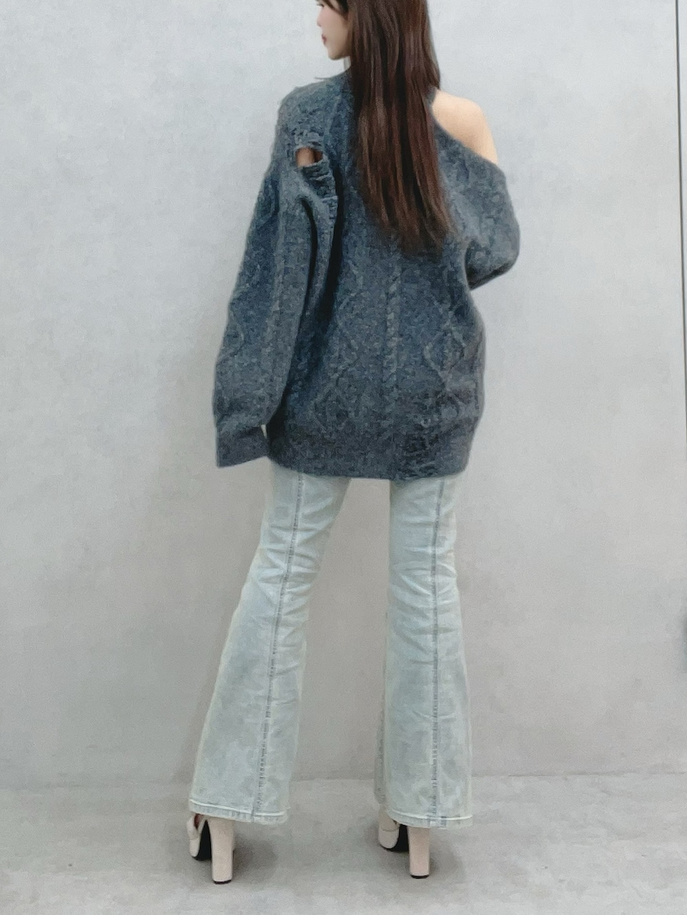 グレー系のニット/セーター、ブルー系のデニムパンツを着用したレディースの冬コーディネートの6枚目の写真