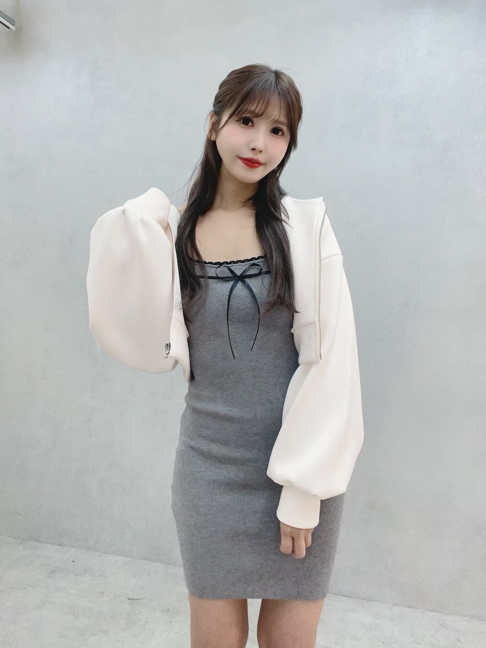 グレー系のワンピース、ホワイト系のパーカー、ホワイト系のブーツを着用したレディースの冬コーディネートの8枚目の写真