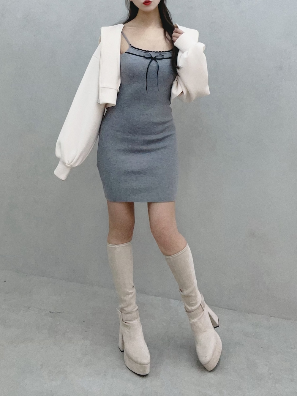 グレー系のワンピース、ホワイト系のパーカー、ホワイト系のブーツを着用したレディースの冬コーディネートの2枚目の写真