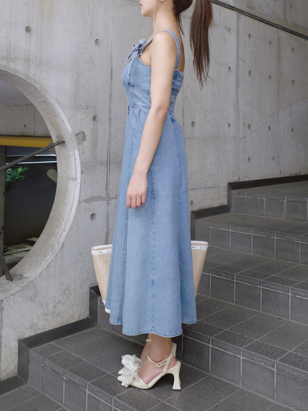 ホワイト系のトートバッグ、イエロー系のパンプス、ブルー系のワンピースを着用したレディースの夏コーディネートの5枚目の写真