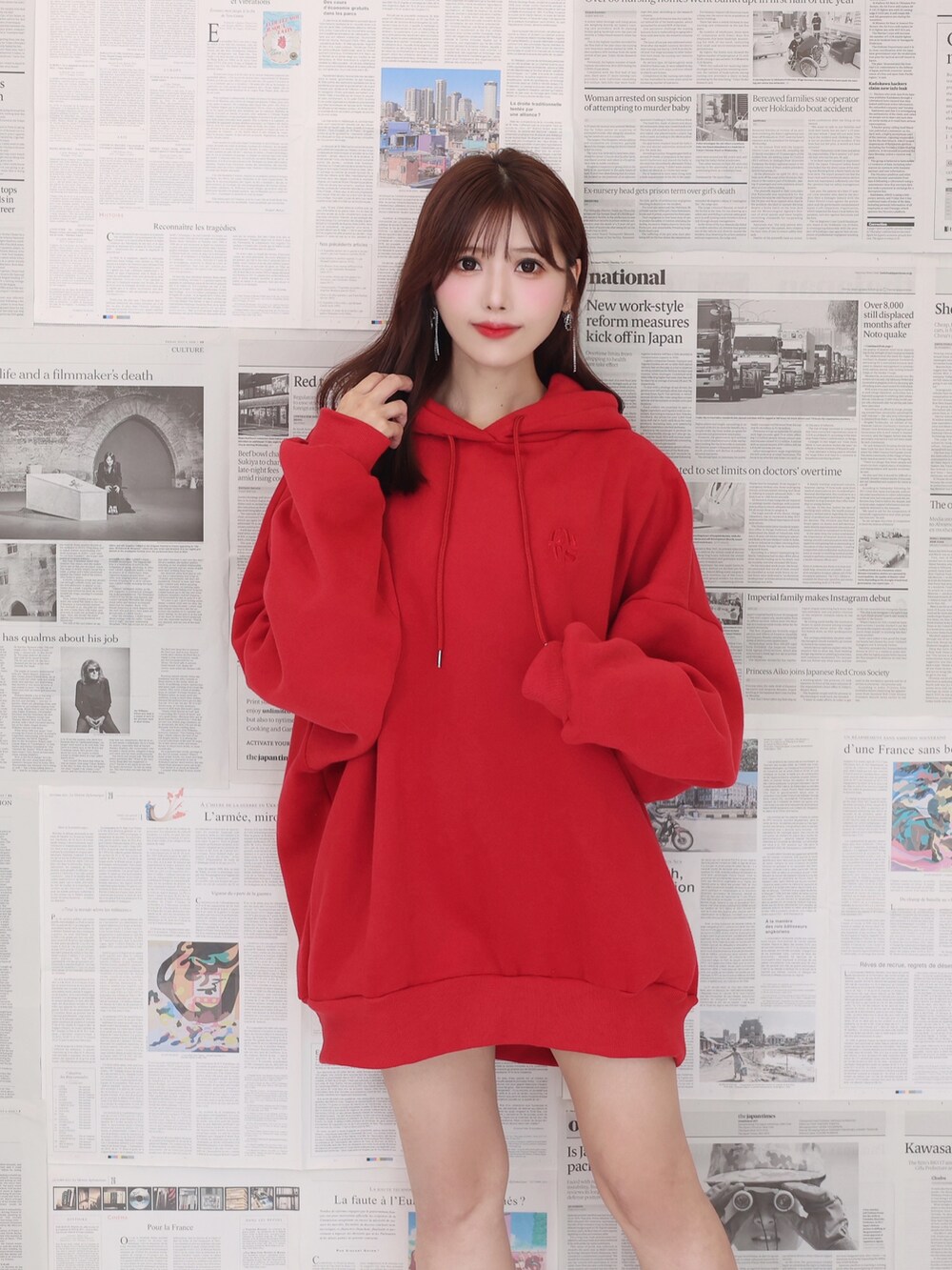 レッド系のパーカー、ブラック系のショルダーバッグ、ブラック系のブーツを着用したレディースの夏コーディネートの5枚目の写真