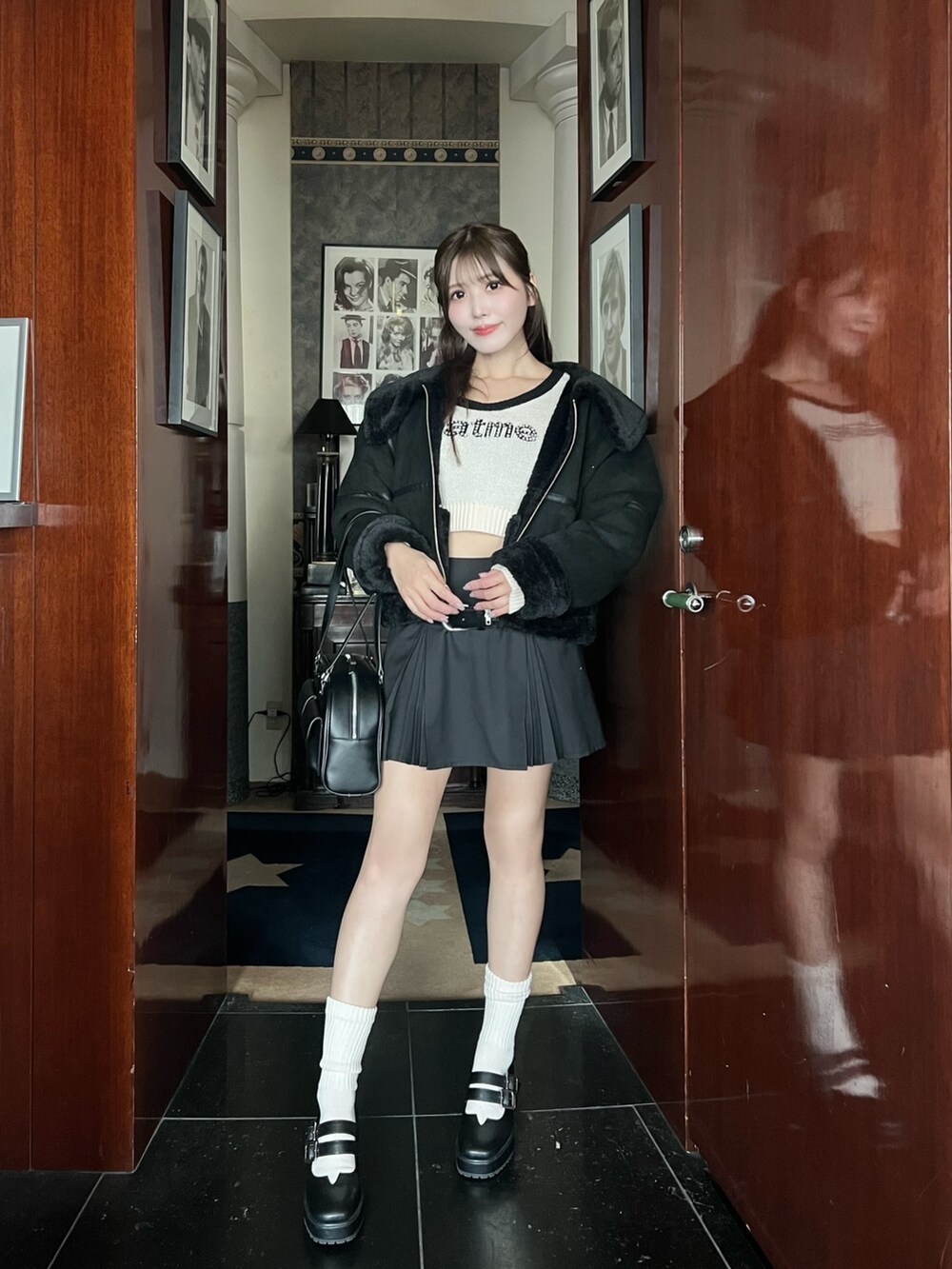 ブラック系のブルゾン、グレー系のスカート、ホワイト系のニット/セーターを着用したレディースの冬コーディネートの3枚目の写真