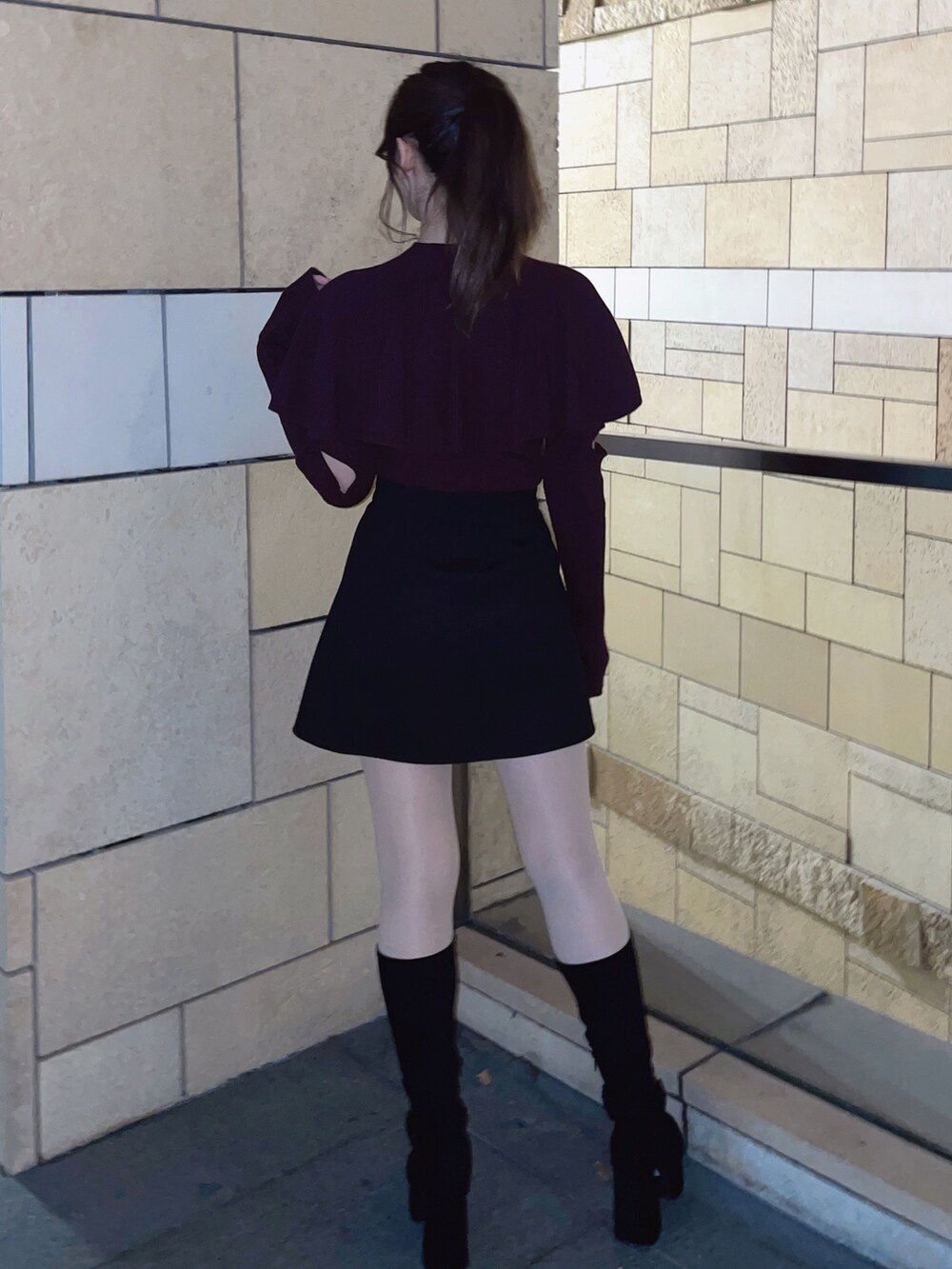 レッド系のニット/セーター、ブラック系のスカートを着用したレディースの冬コーディネートの7枚目の写真