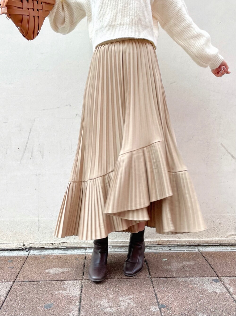 ブラウン系のクラッチバッグ、ホワイト系のニット/セーター、ブラウン系のブーツを着用したレディースの冬コーディネートの4枚目の写真