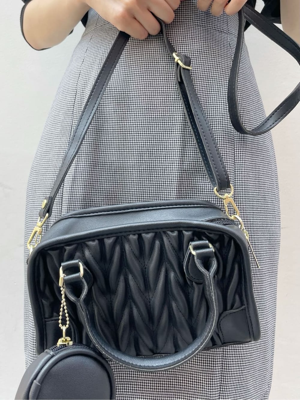 ブラック系のスカート、ブラック系のニット/セーター、ブラック系のハンドバッグを着用したレディースの秋コーディネートの9枚目の写真