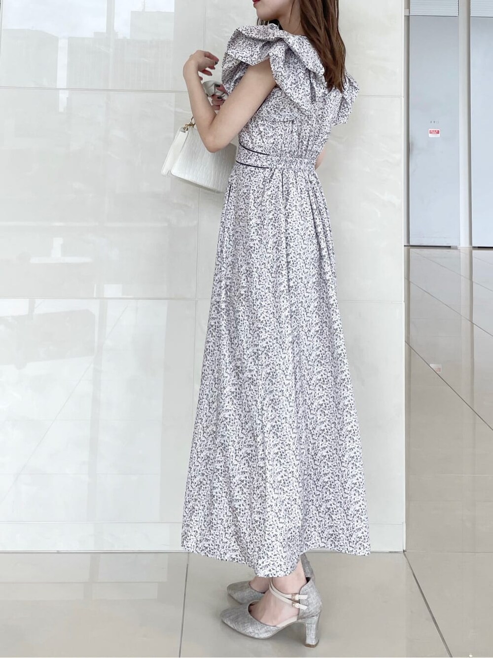 グレー系のパンプス、ホワイト系のワンピースを着用したレディースの秋コーディネートの3枚目の写真