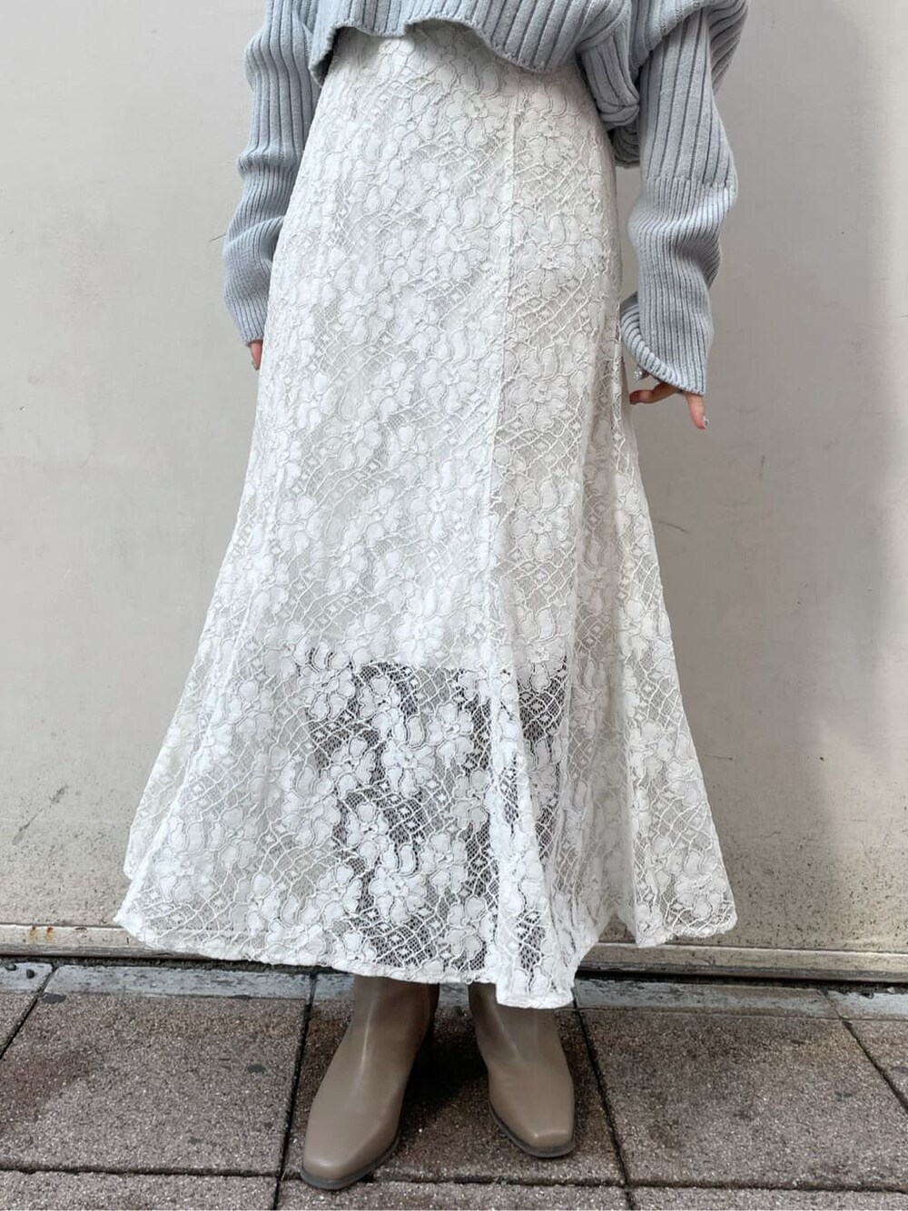 ホワイト系のスカート、ベージュ系のブーツ、ブルー系のニット/セーターを着用したレディースの秋コーディネートの10枚目の写真