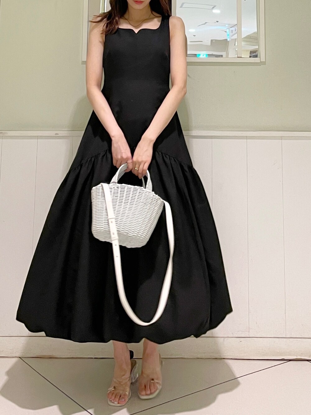 ブラック系のワンピース、ホワイト系のサンダル、ホワイト系のハンドバッグを着用したレディースの夏コーディネートの4枚目の写真