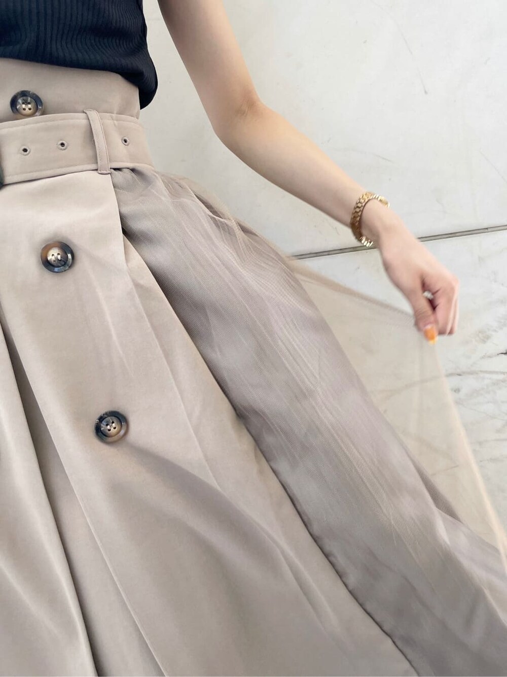 ブラック系のサンダル、ブラック系のTシャツ/カットソー、ベージュ系のスカートを着用したレディースの夏コーディネートの9枚目の写真