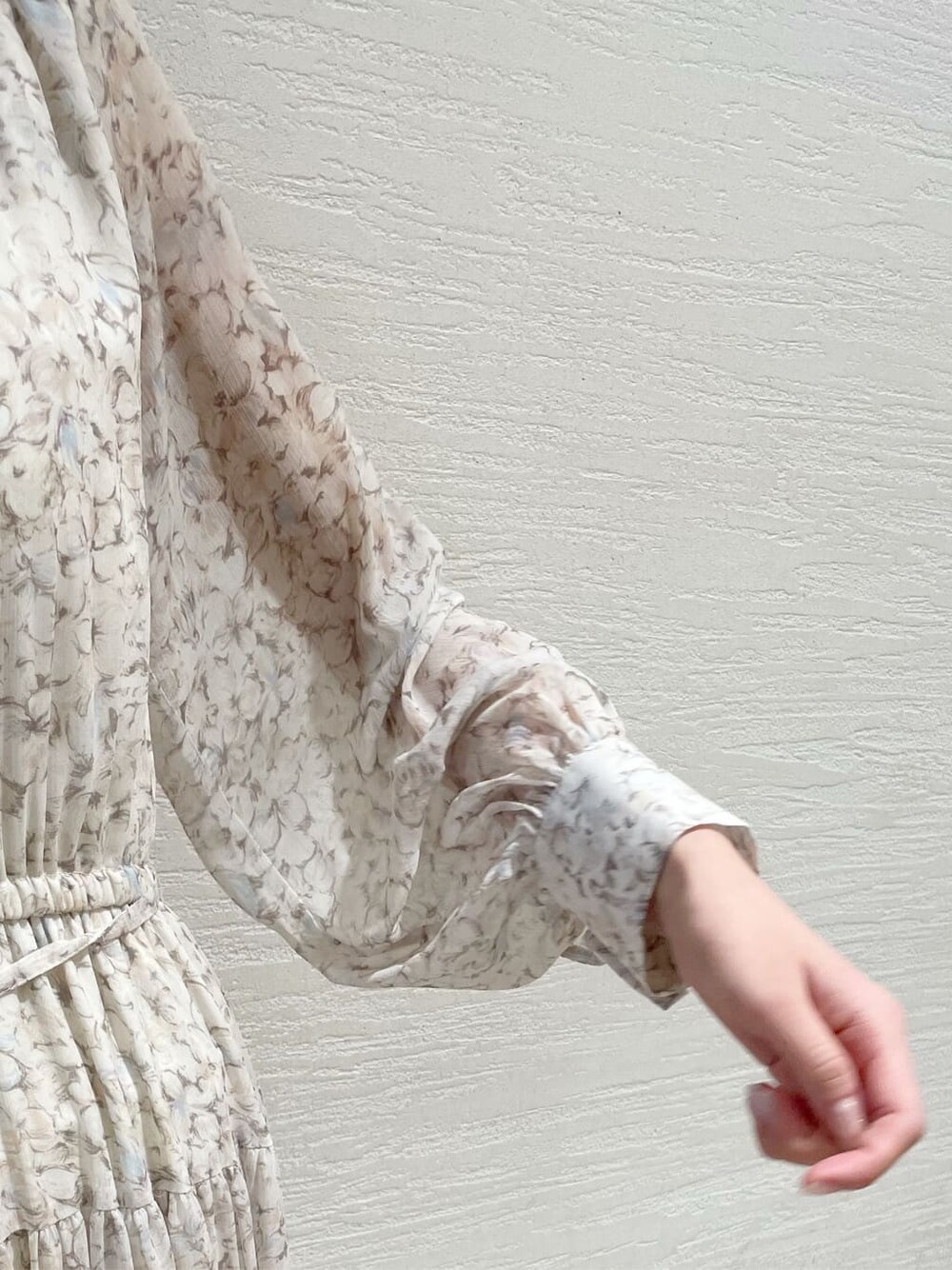 グレー系のトレンチコート、オレンジ系のワンピース、グレー系のニット/セーターを着用したレディースの冬コーディネートの10枚目の写真