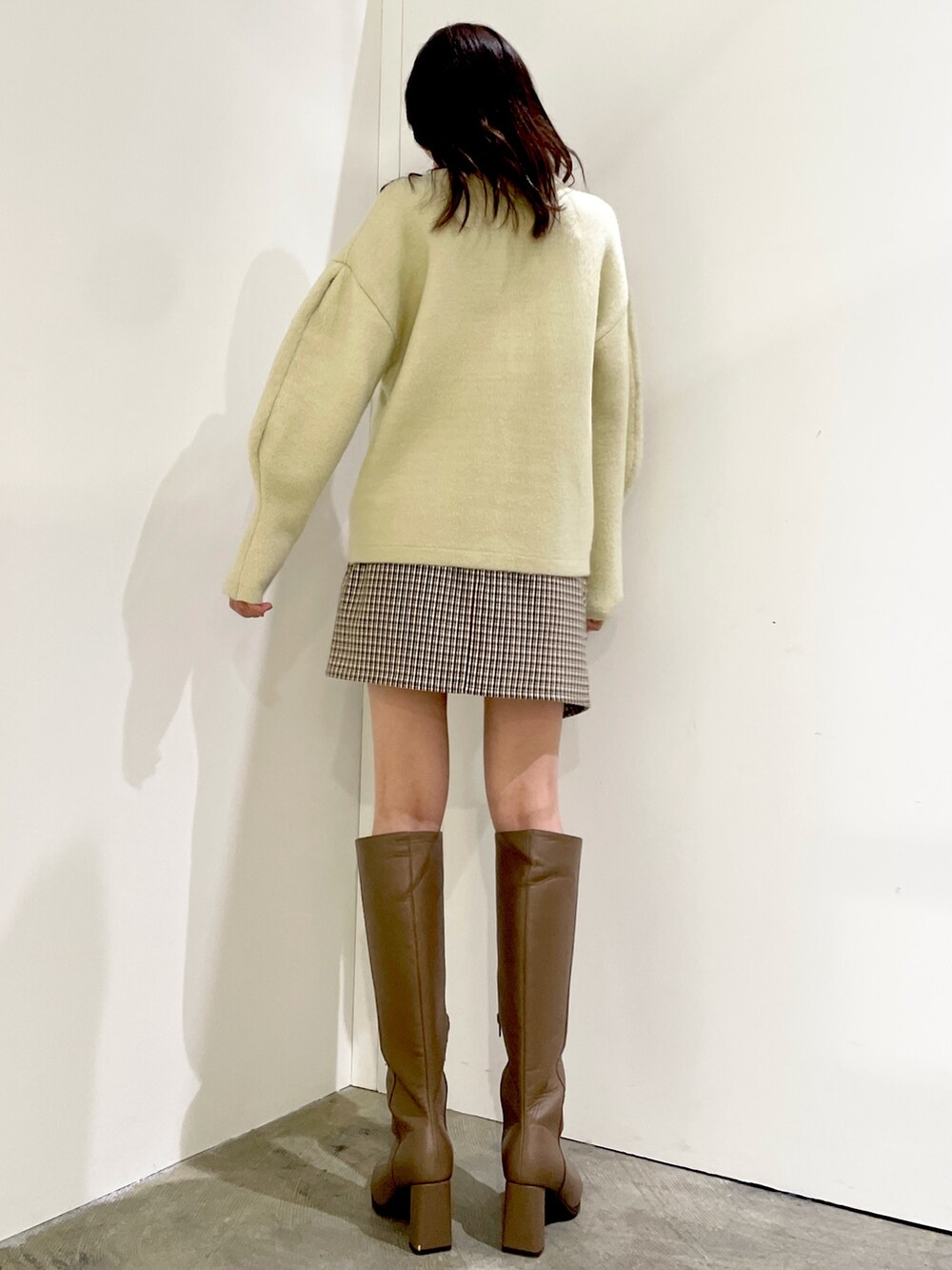 グリーン系のカーディガン/ボレロ、ブラウン系のスカート、ベージュ系のブーツを着用したレディースの秋コーディネートの3枚目の写真