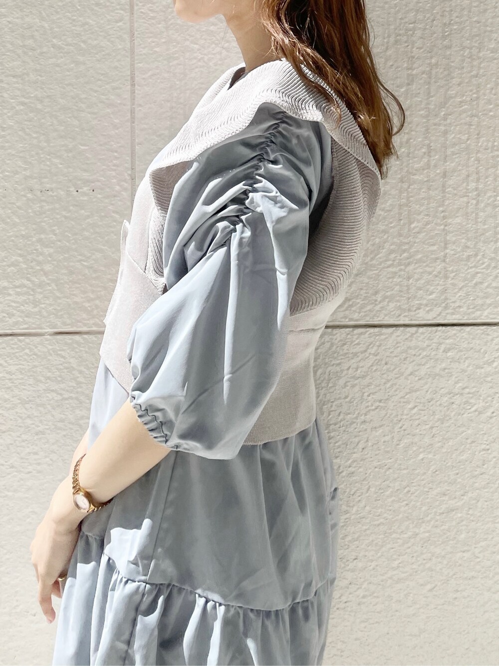 ホワイト系のスニーカー、ホワイト系のショルダーバッグ、ブルー系のチュニックを着用したレディースの春コーディネートの7枚目の写真