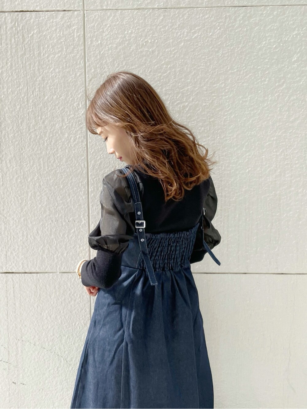 ホワイト系のブーツ、ブラック系のニット/セーター、ブルー系のワンピースを着用したレディースの冬コーディネートの9枚目の写真