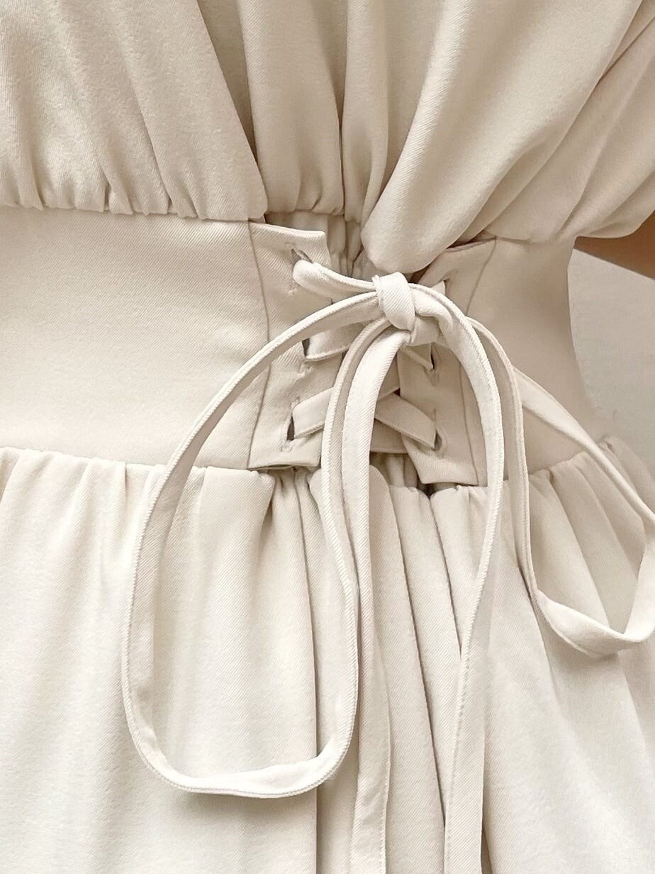 ブラック系のサンダル、ブラック系のハンドバッグ、ホワイト系のワンピースを着用したレディースの春コーディネートの8枚目の写真