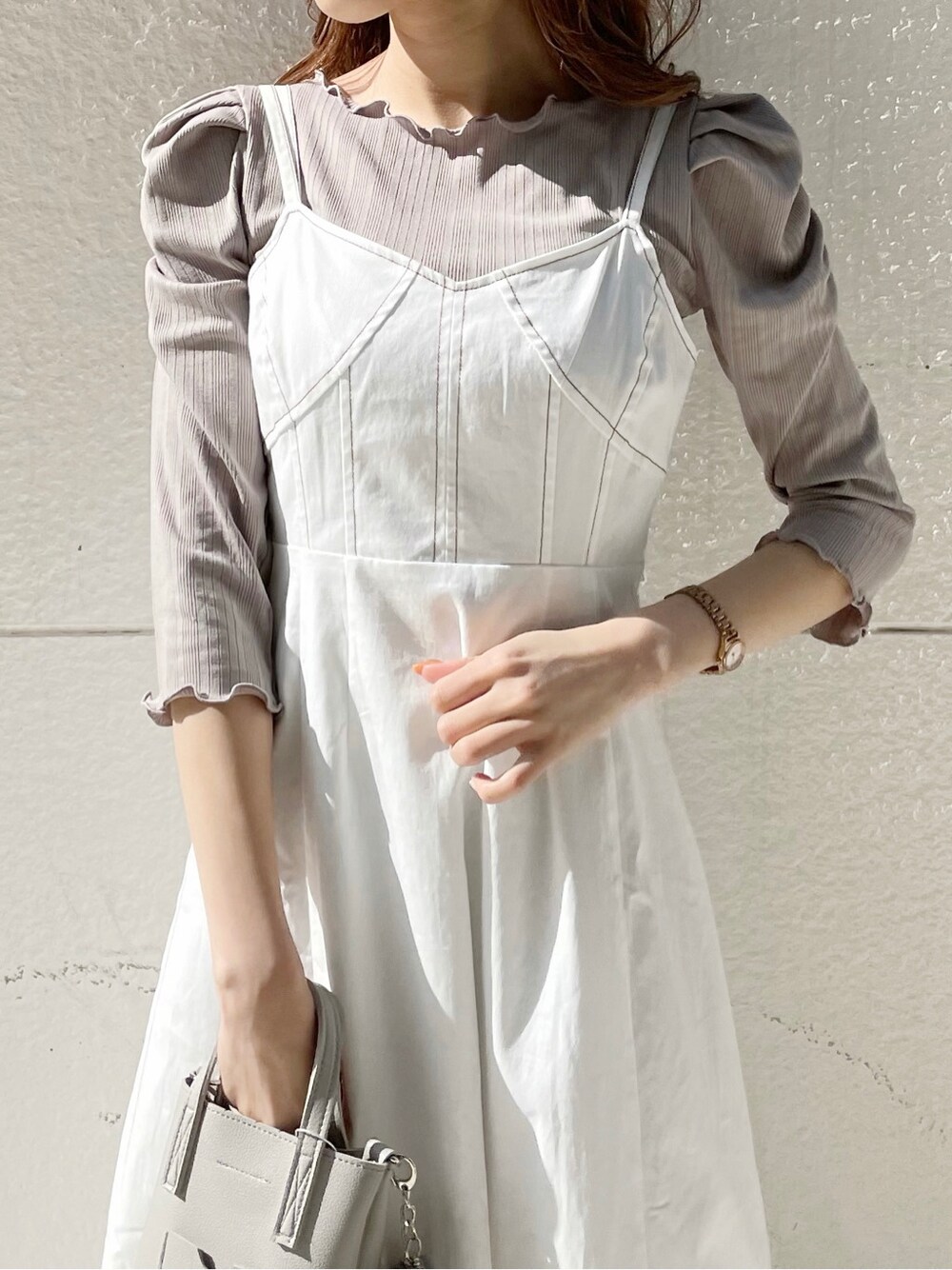 ベージュ系のTシャツ/カットソー、ホワイト系のワンピース、ホワイト系のパンプスを着用したレディースの冬コーディネートの5枚目の写真