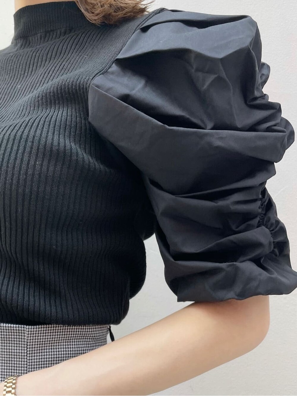 ブラック系のスカート、ブラック系のニット/セーター、ブラック系のハンドバッグを着用したレディースの秋コーディネートの6枚目の写真