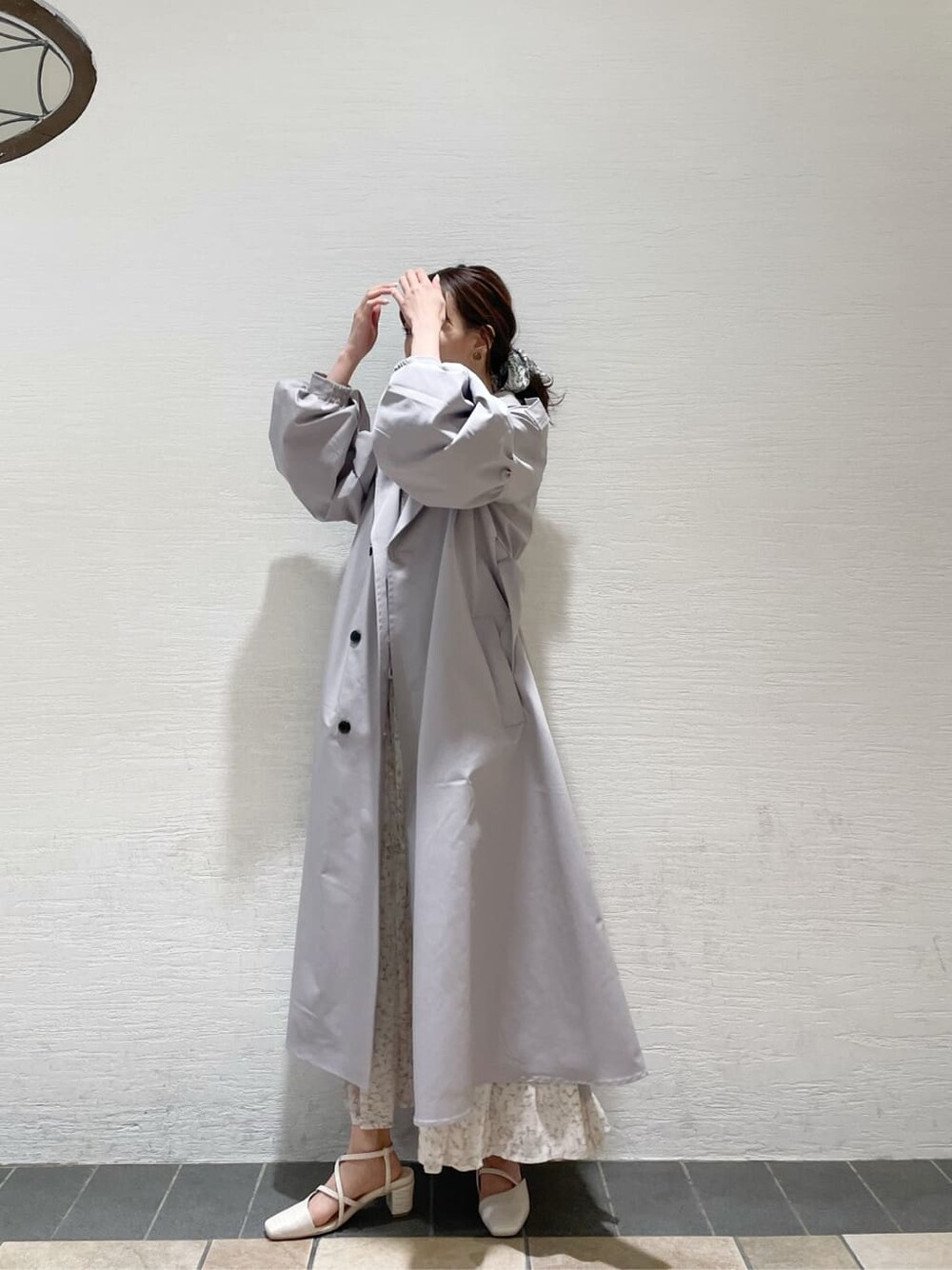 グレー系のトレンチコート、オレンジ系のワンピース、グレー系のニット/セーターを着用したレディースの冬コーディネートの4枚目の写真