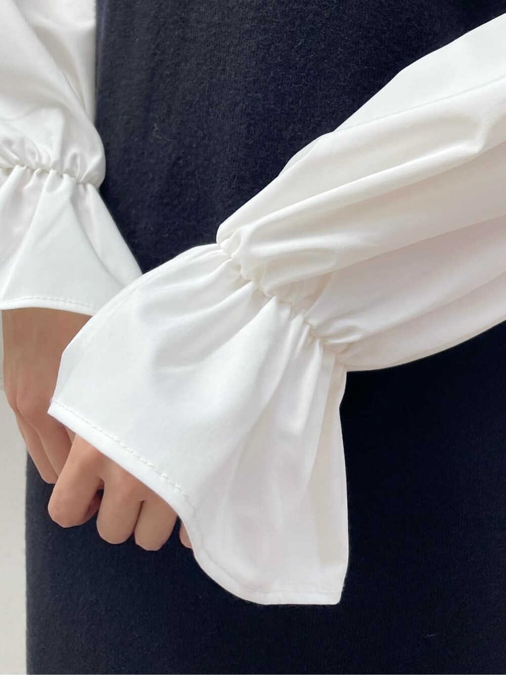 ブラック系のブーツ、ブラック系のワンピース、ベージュ系のハンドバッグを着用したレディースの秋コーディネートの9枚目の写真