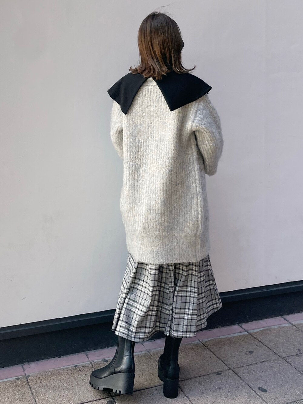 ブルー系のカーディガン/ボレロ、グレー系のワンピース、ブラック系のブーツを着用したレディースの冬コーディネートの3枚目の写真