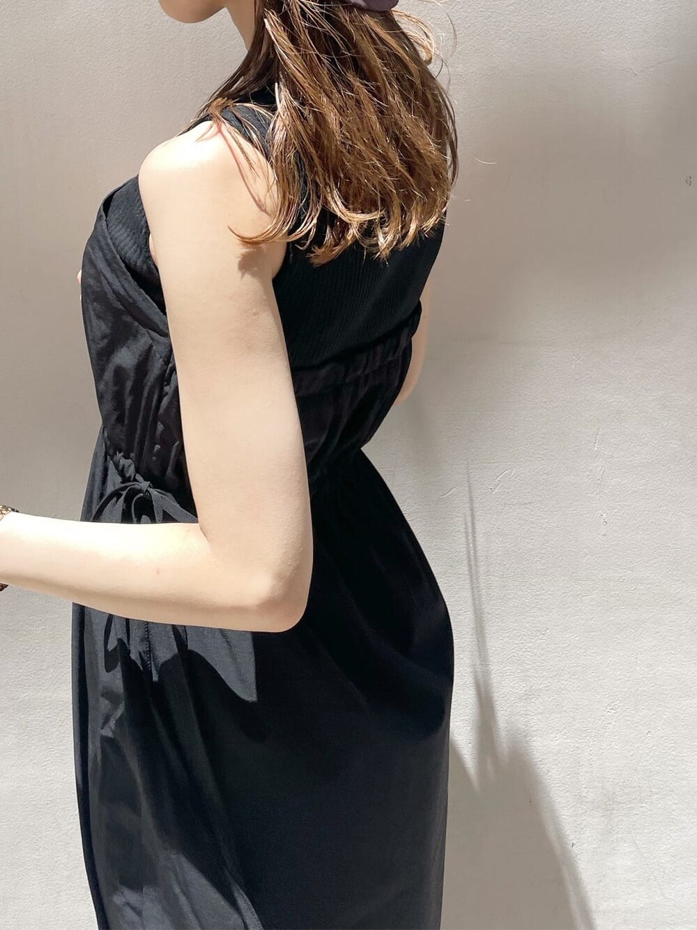 ブラック系のワンピース、ホワイト系のサンダルを着用したレディースの夏コーディネートの5枚目の写真