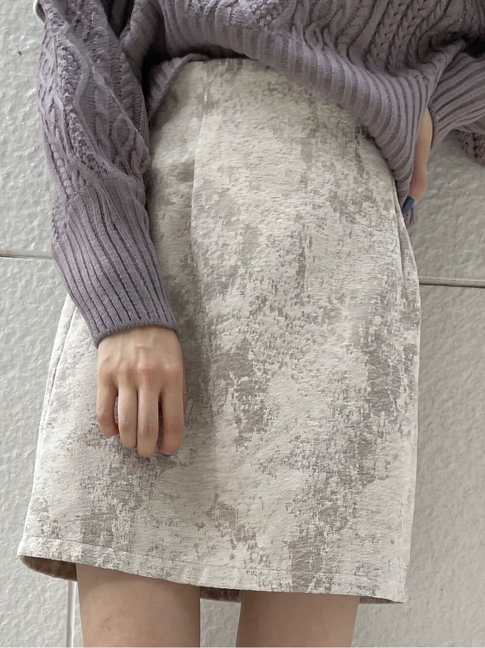 ベージュ系のスカート、ブラック系のブーツ、パープル系のニット/セーターを着用したレディースの秋コーディネートの9枚目の写真