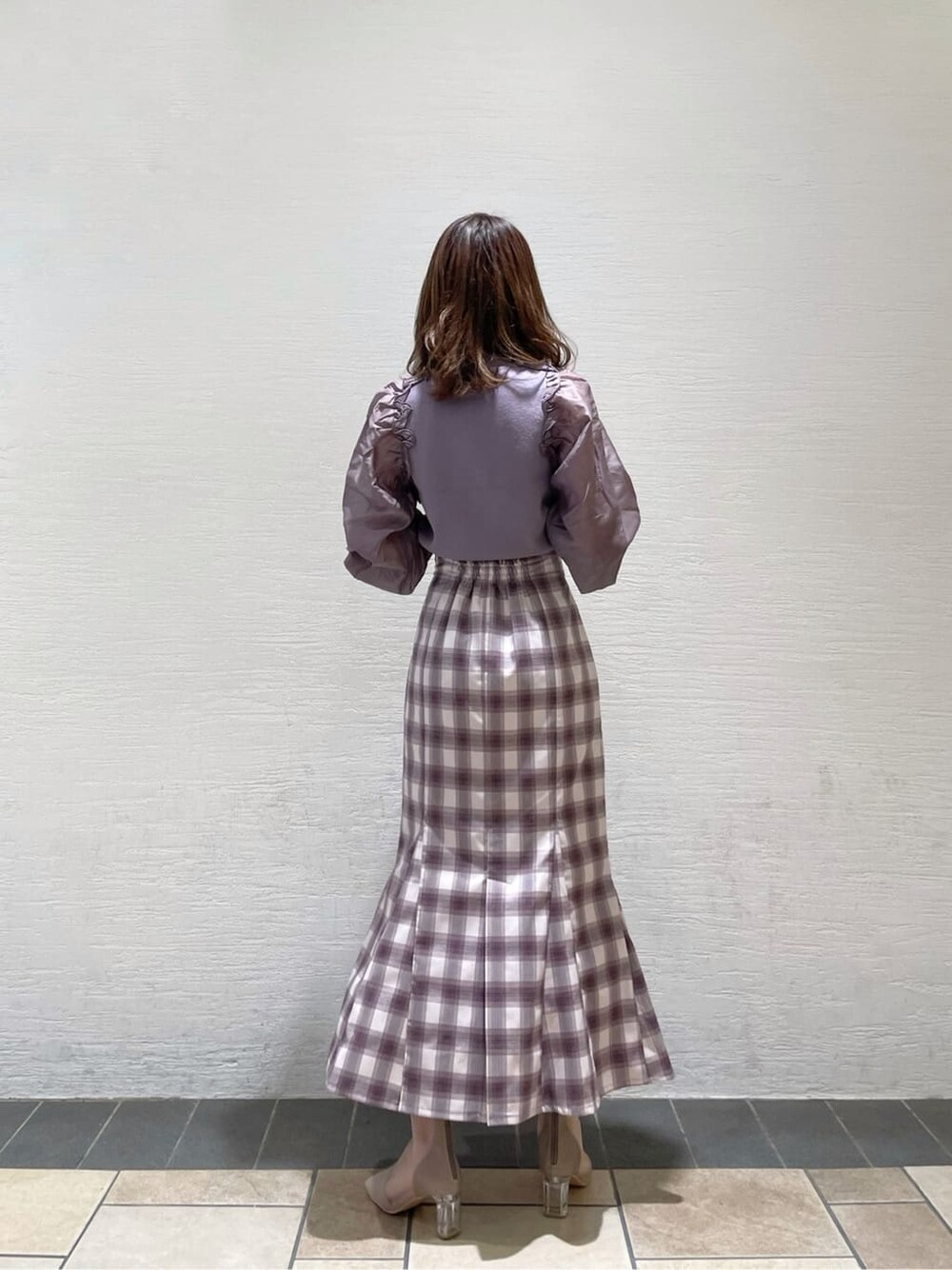 パープル系のスカート、ベージュ系のブーツ、パープル系のニット/セーターを着用したレディースの冬コーディネートの3枚目の写真