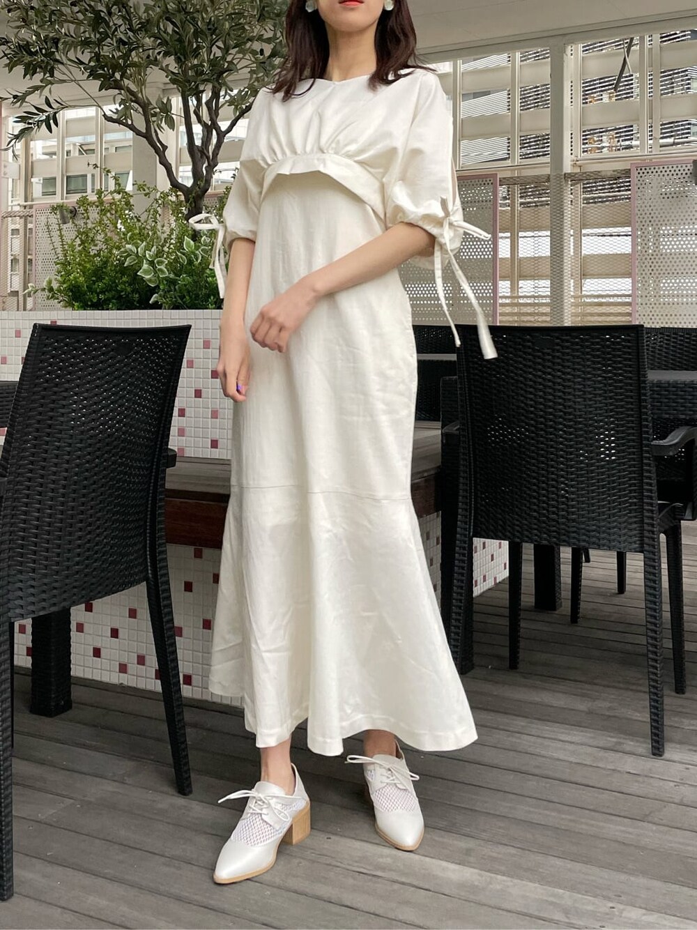 ベージュ系のデニムジャケット、ホワイト系のワンピース、ホワイト系のローファーを着用したレディースの春コーディネートの3枚目の写真