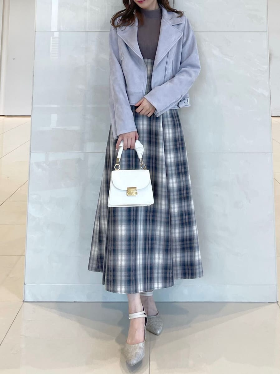 ベージュ系のワンピース、パープル系のライダースジャケット、グレー系のパンプスを着用したレディースの秋コーディネートの2枚目の写真