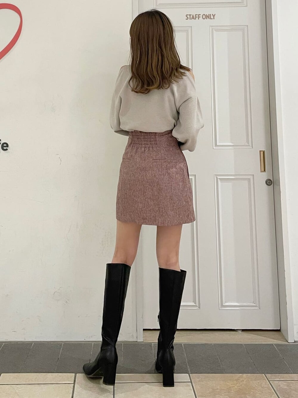 グレー系のニット/セーター、レッド系のスカート、ブラック系のブーツを着用したレディースの夏コーディネートの5枚目の写真