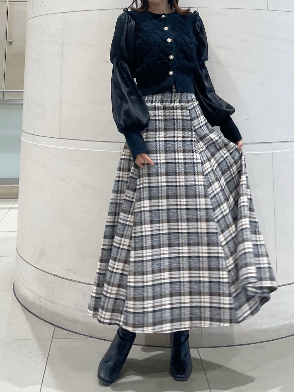 その他のスカート、ブラック系のニット/セーター、ブラック系のブーツを着用したレディースの冬コーディネートの2枚目の写真