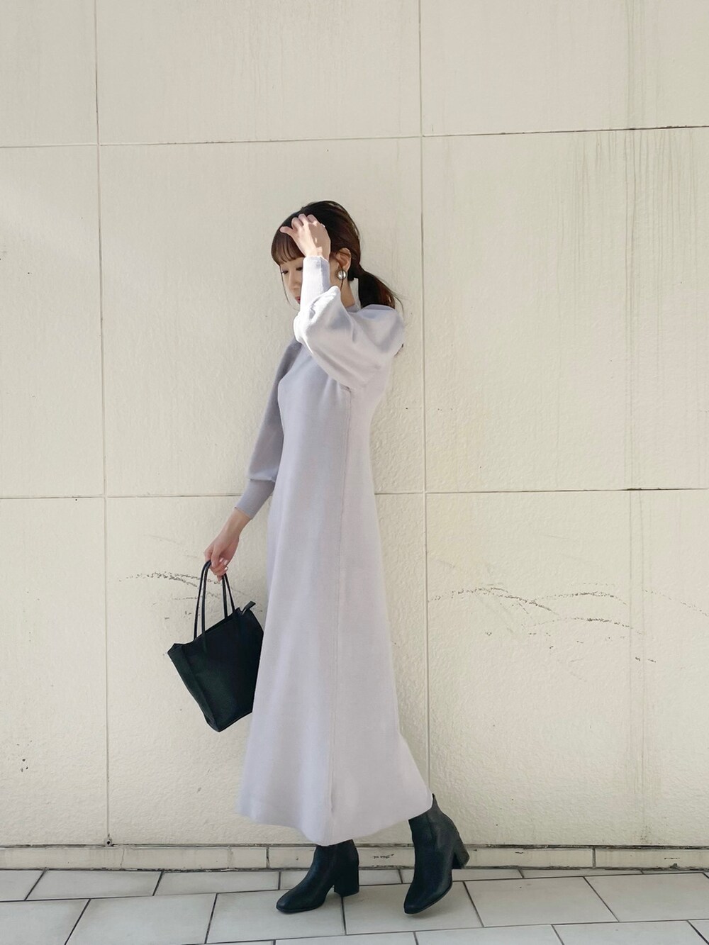 ブラック系のブーツ、ブラック系のハンドバッグ、グレー系のワンピースを着用したレディースの冬コーディネートの3枚目の写真