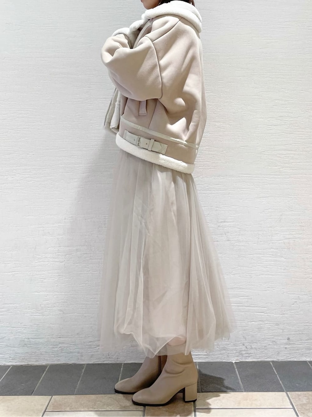 ベージュ系のスカート、ホワイト系のブルゾン、ブラウン系のニット/セーターを着用したレディースの夏コーディネートの3枚目の写真