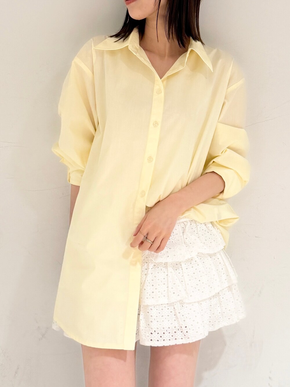 イエロー系のシャツ/ブラウス、ホワイト系のスカート、ブラウン系のブーツを着用したレディースの春コーディネートの3枚目の写真