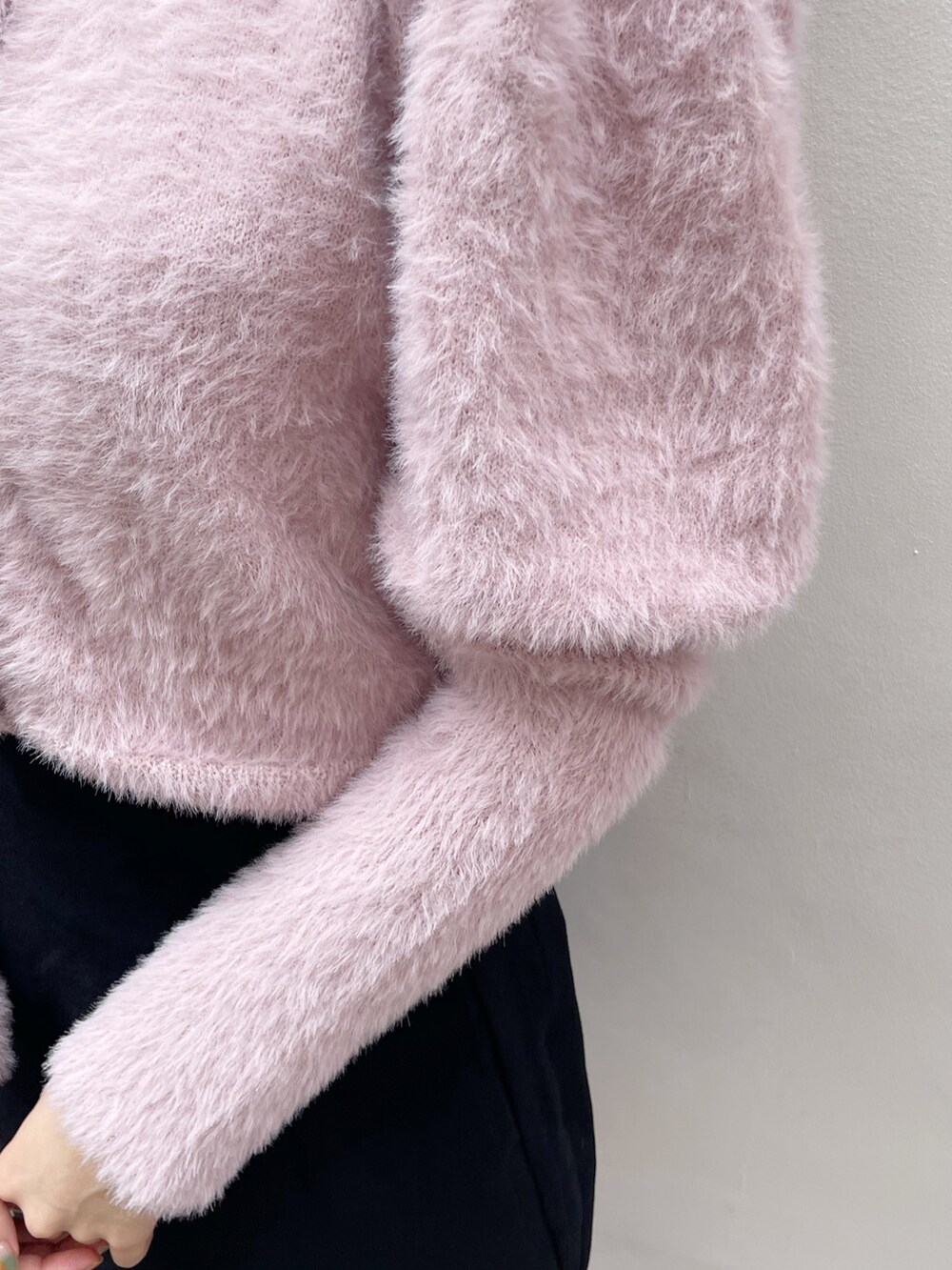 ピンク系のニット/セーター、ブラック系のスカート、ブラック系のブーツを着用したレディースの冬コーディネートの6枚目の写真