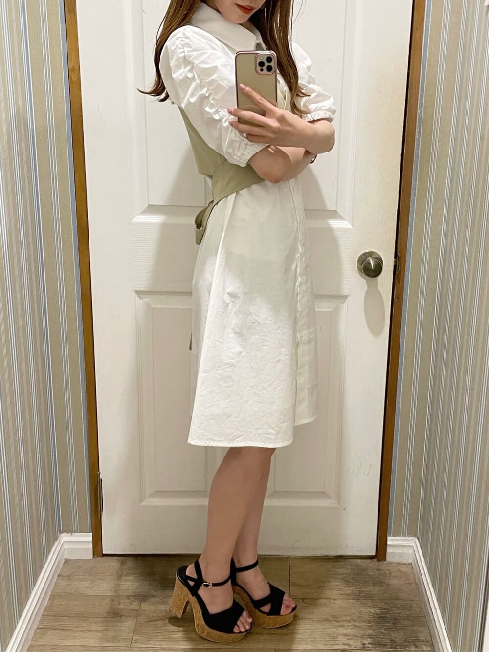 ブラック系のサンダル、ホワイト系のシャツワンピース、ブラウン系のイヤリングを着用したレディースの夏コーディネートの2枚目の写真