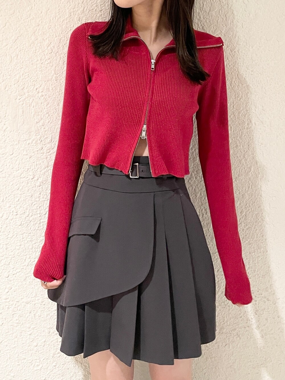 レッド系のニット/セーター、ブラック系のブーツ、グレー系のスカートを着用したレディースの冬コーディネートの7枚目の写真