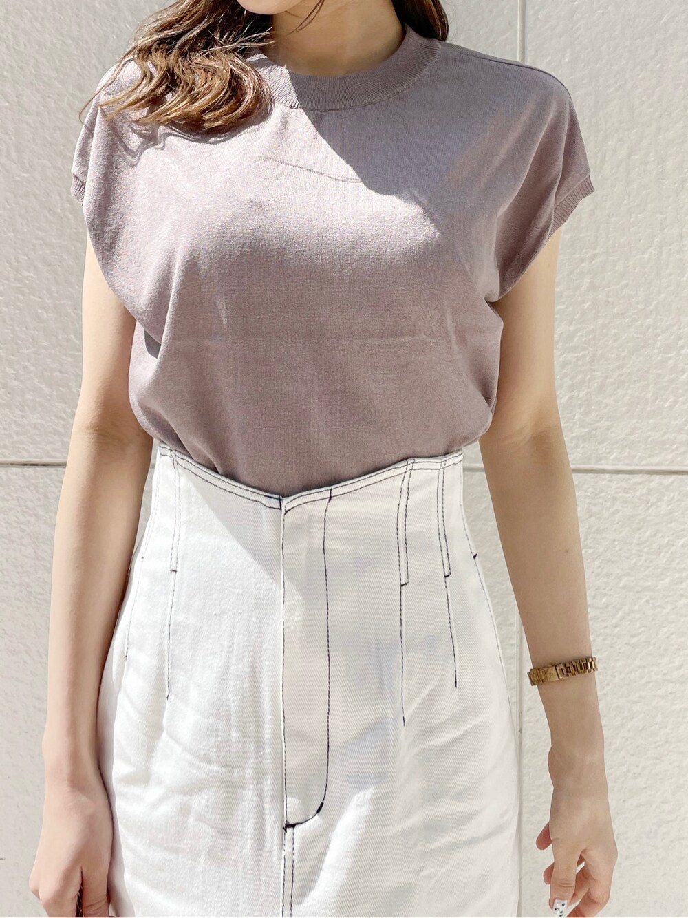 ホワイト系のスカート、ホワイト系のパンプス、ホワイト系のショルダーバッグを着用したレディースの春コーディネートの10枚目の写真