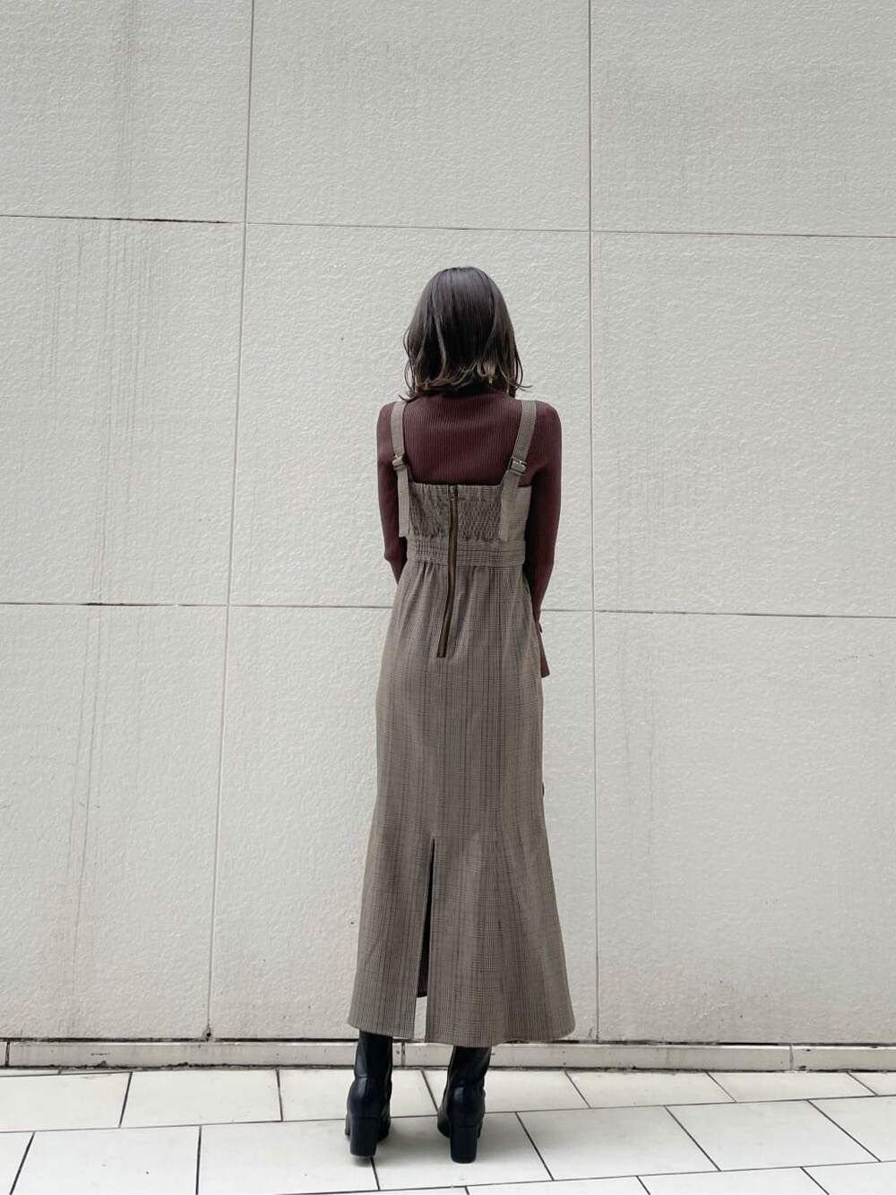 ベージュ系のライダースジャケット、ブラック系のブーツ、その他のジャンパースカートを着用したレディースの秋コーディネートの4枚目の写真