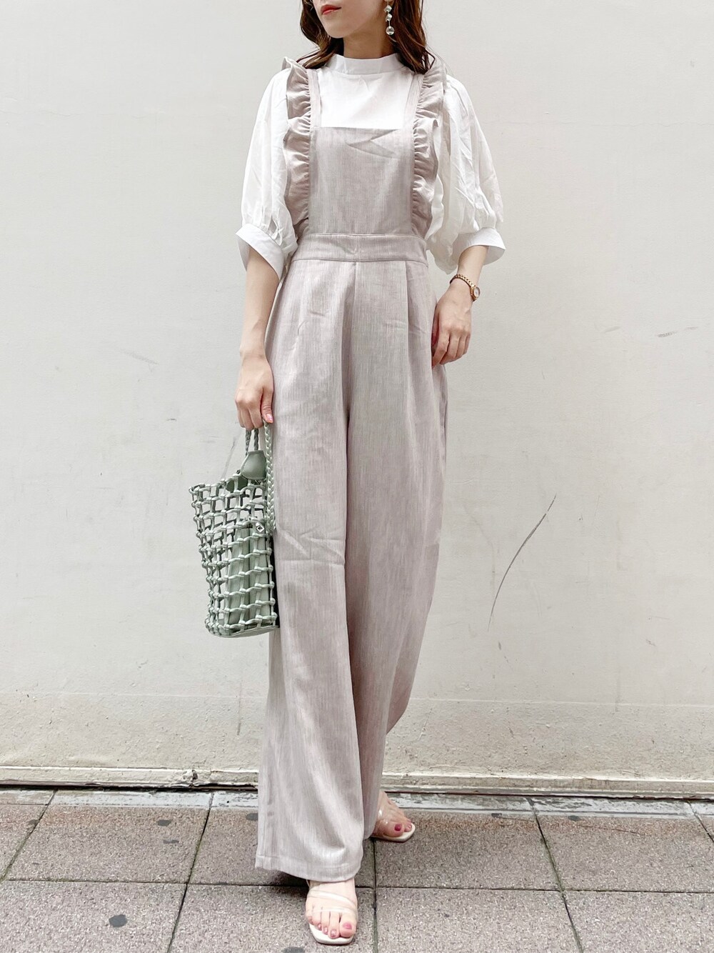 ブラウン系のサロペット/オーバーオール、ホワイト系のシャツ/ブラウス、グリーン系のショルダーバッグを着用したレディースの夏コーディネートの4枚目の写真