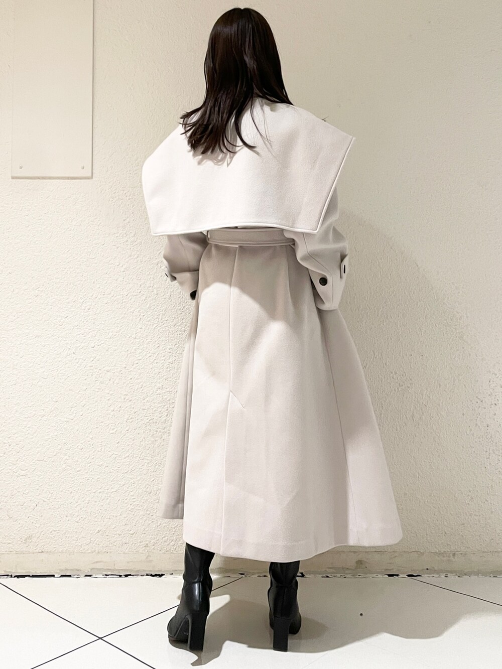 ホワイト系のその他アウター、ブラック系のブーツ、グレー系のワンピースを着用したレディースの冬コーディネートの4枚目の写真