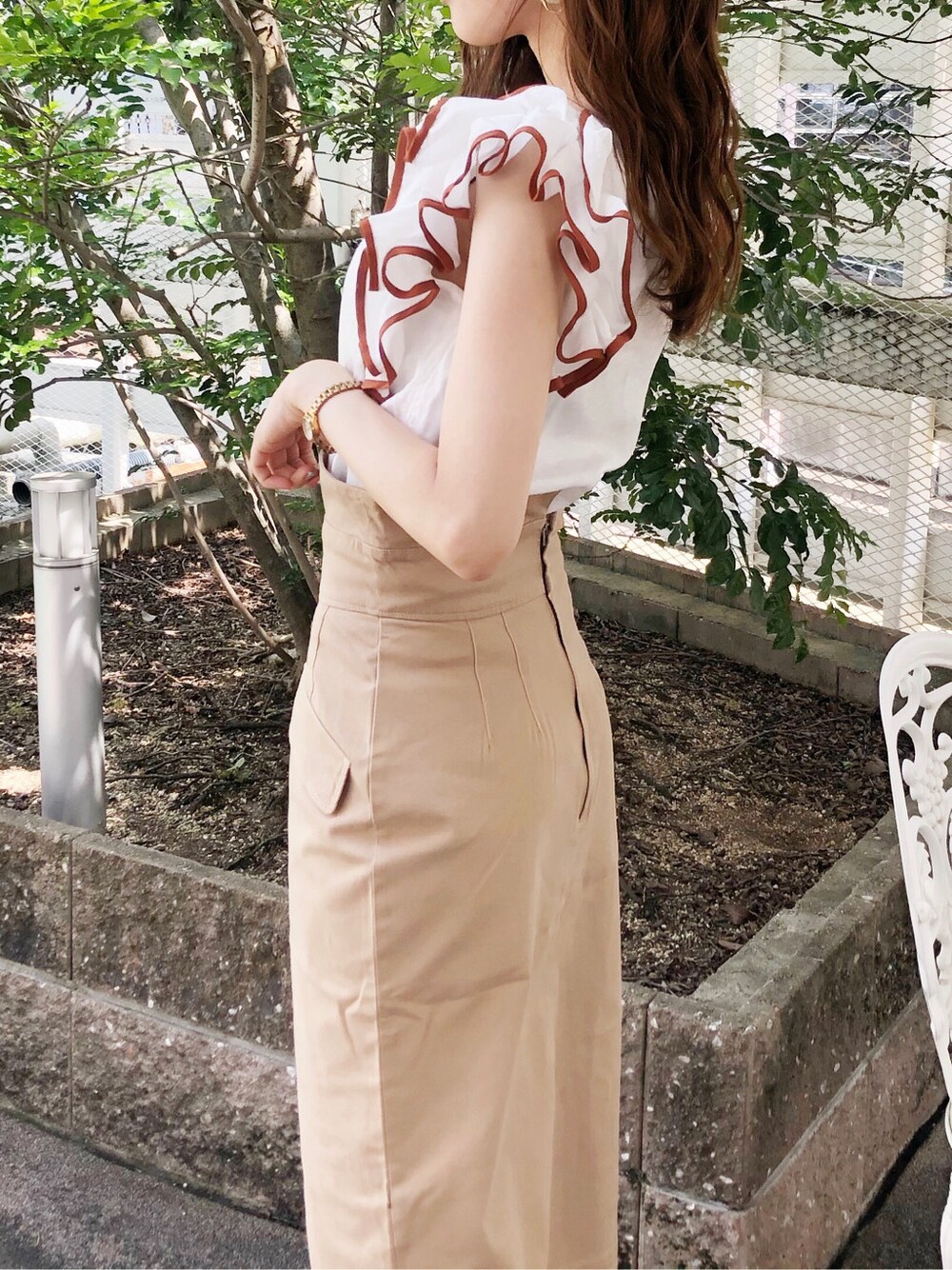 ベージュ系のハンドバッグ、ホワイト系のシャツ/ブラウス、ブラウン系のサンダルを着用したレディースの夏コーディネートの3枚目の写真