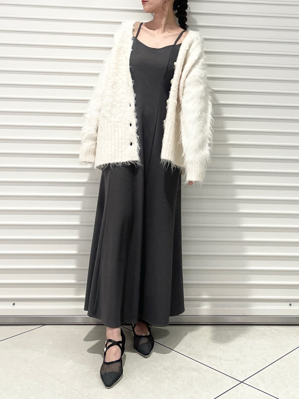 グレー系のワンピース、ブラック系のパンプス、ホワイト系のカーディガン/ボレロを着用したレディースの春コーディネートの4枚目の写真